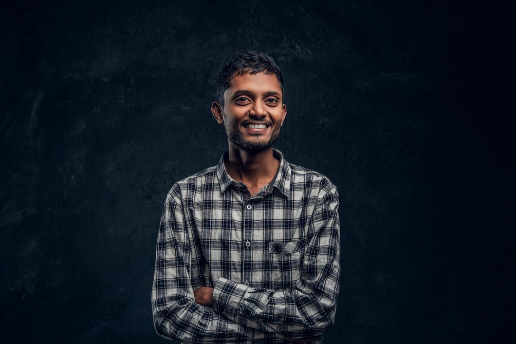 cheerful-hindu-guy-posing-laughing-crossed-his-arms-studio-black-background_613910-20913